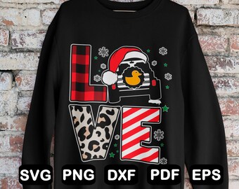 Puede incluir: Sudadera negra con un diseño de cuadros rojos y negros, estampado de leopardo y rayas rojas y blancas que deletrean "LOVE". Un jeep negro con un pato de goma amarillo y un gorro de Papá Noel está en el centro del diseño.