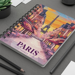 Puede incluir: Cuaderno de espiral con una colorida ilustración de París, Francia, con la Torre Eiffel y escenas de café. La palabra "PARIS" se muestra prominentemente en la portada. Incluye encuadernación en espiral negra e interior de papel blanco.