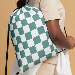 May include: A green and white checkered drawstring bag. The bag is made of a soft, durable fabric and has a simple, stylish design.