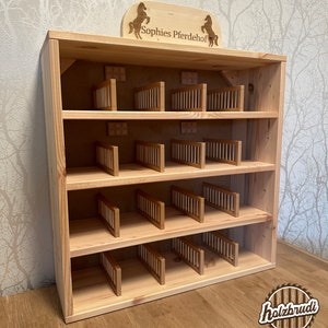 Pode incluir: Estábulo de brinquedo de madeira com quatro níveis e múltiplos boxes. O estábulo é feito de madeira natural e tem uma placa que diz "Sophie's Pferdehof".