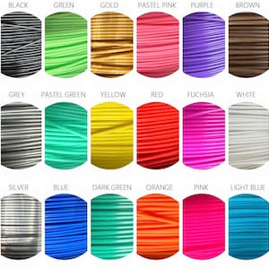 May include: A color chart featuring samples of filament for 3D printing. Colors include black, green, gold, pastel pink, purple, brown, grey, pastel green, yellow, red, fuchsia, white, silver, blue, dark green, orange, pink, and light blue.