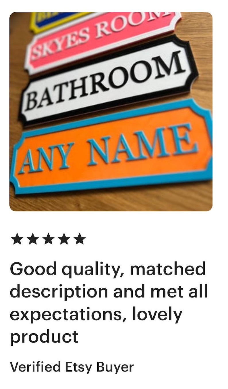May include: A close-up of three decorative signs. The top sign is pink with white text that reads "SKYES ROOM". The middle sign is black with white text that reads "BATHROOM". The bottom sign is orange with blue text that reads "ANY NAME".