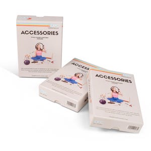 Könnte beinhalten: Drei Accessoire-Boxen werden vor einem weißen Hintergrund präsentiert. Die Boxen sind hellbeige mit dem Wort "ACCESSORIES" in Schwarz. Jede Box zeigt eine Illustration einer Person mit Kopfhörern. Die Boxen haben einen Regenbogenstreifen.