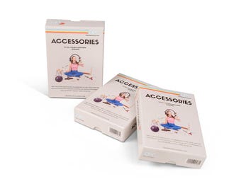 Op de afbeelding: Drie dozen accessoires worden gepresenteerd tegen een witte achtergrond. De dozen zijn lichtbeige met het woord "ACCESSORIES" in het zwart. Elke doos bevat een illustratie van een persoon met een koptelefoon. De dozen hebben een regenboogstreep.
