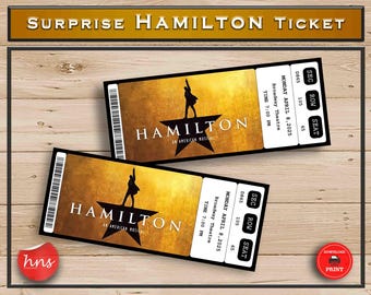 May include: Two printable tickets for the musical Hamilton. The tickets are gold with black text and a silhouette of a person in a star. The text on the tickets reads "Hamilton, An American Musical". The tickets also include the date, time, and location of the performance.
