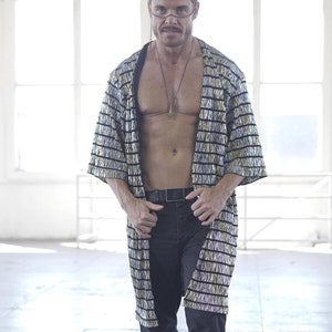 May include: A person wearing a black and silver striped robe with a black belt and black boots.
