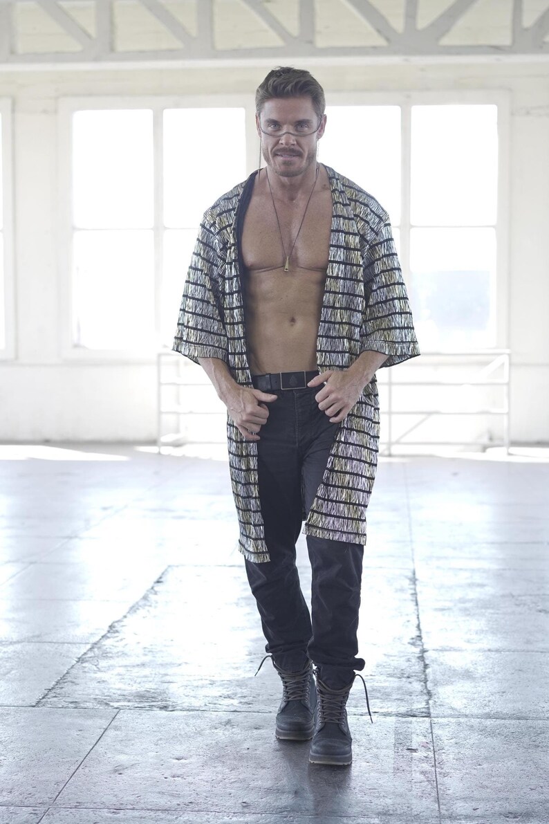 May include: A person wearing a black and silver striped robe with a black belt and black boots.