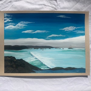May include: Acrylic painting of a coastal landscape featuring a bright blue sky with fluffy white clouds. The ocean is a light turquoise color, with a wave breaking near the center. Dark cliffs and land formations frame the water.
