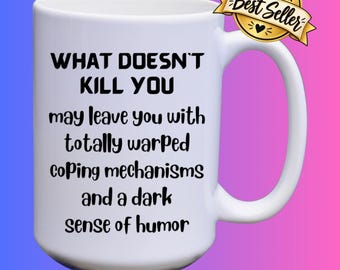 Può includere: Una tazza in ceramica bianca con testo nero che recita: WHAT DOESN'T KILL YOU may leave you with totally warped coping mechanisms and a dark sense of humor. Un distintivo color oro con la scritta SHOP Best Seller è fissato al manico.