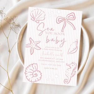 Puede incluir: Una tarjeta de invitación rectangular para baby shower con fondo de rayas verticales en rosa claro y blanco, con ilustraciones de líneas rosas de conchas marinas, un caballito de mar y un lazo. El texto dice Sea you soon baby, please join us for a baby shower honoring Isabella Smith, Sat, March 16th, at 3pm, 123 Anywhere St., Any City, RSVP to: +1-234-567-7890, registered at baby store.