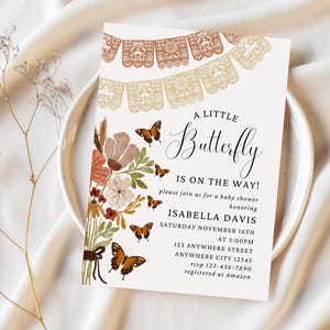 May include: A baby shower invitation featuring a floral design and butterflies. The invitation is for a baby shower in honour of Isabella Davis on Saturday, 16th November at 3:00 PM. The address is 123 Anywhere Street, Anywhere City 12345. The RSVP number is 123-456-7890 and the registry is at Amazon.