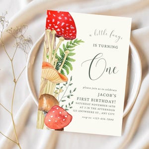 Puede incluir: Una invitación de primer cumpleaños con temática de hongos con una ilustración de acuarela de hongos rojos y marrones, helechos verdes y el texto "a little fungi is turning one". La invitación incluye el nombre "Jacob's" y la fecha "Saturday November 16th".
