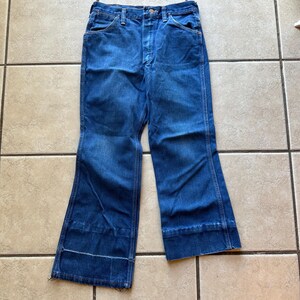 May include: A pair of blue denim jeans with a wide leg and a cuffed hem.