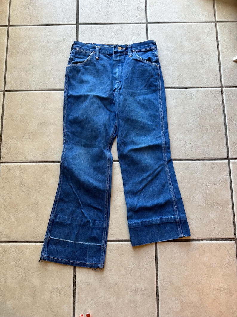 May include: A pair of blue denim jeans with a wide leg and a cuffed hem.