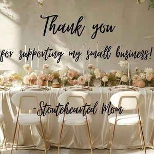 May include: A white tablecloth with a long table set with white chairs and floral centerpieces. The text "Thank you for supporting my small business! -Stoutehearted Mom" is written on the wall behind the table.