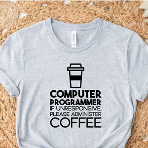 May include: Gray t-shirt with a black graphic of a coffee cup and the text "COMPUTER PROGRAMMER IF UNRESPONSIVE, PLEASE ADMINISTER COFFEE".