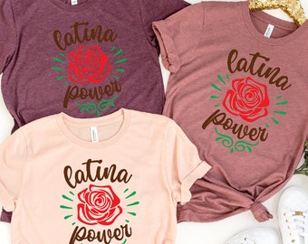 May include: Three t-shirts with the text "Latina Power" and a red rose graphic. The shirts are in pink, maroon, and heather grey.