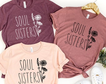 May include: Three t-shirts with the text "Soul Sisters" and a floral design. The shirts are in pink, maroon, and a darker maroon color.