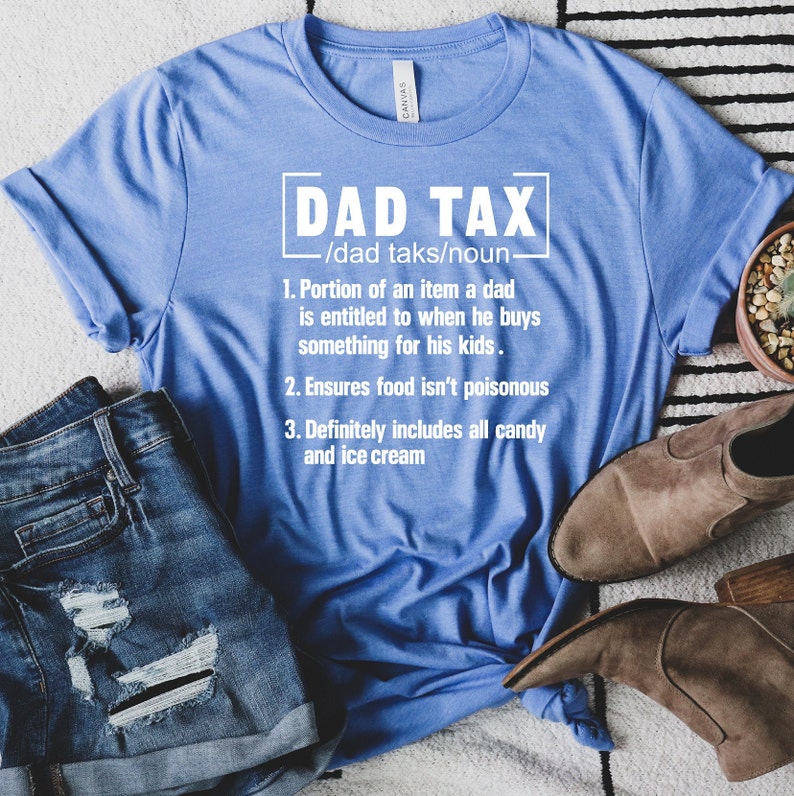 K&ouml;nnte beinhalten: Ein blaues T-Shirt mit wei&szlig;em Text, der "DAD TAX /dad taks/noun 1. Portion of an item a dad is entitled to when he buys something for his kids. 2. Ensures food isn't poisonous 3. Definitely includes all candy and ice cream" lautet.