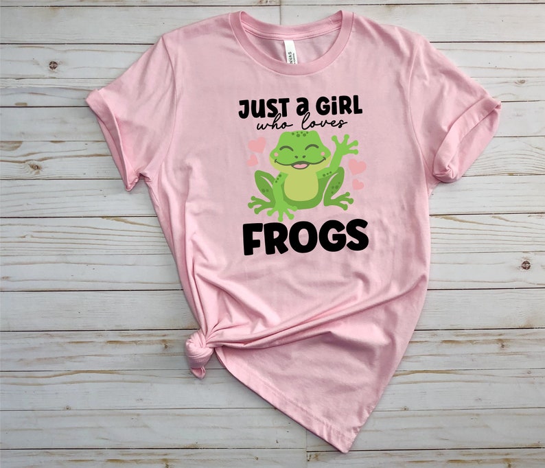 K&ouml;nnte beinhalten: Pinkes T-Shirt mit einem gr&uuml;nen Frosch-Motiv und dem Text "Just a girl who loves frogs".