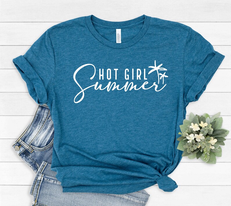 May include: A teal blue t-shirt with the text "Hot Girl Summer" in white cursive lettering and a palm tree graphic.