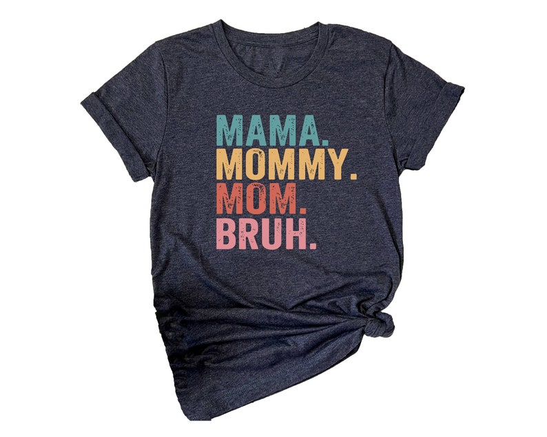 May include: A dark blue t-shirt with the text "MAMA. MOMMY. MOM. BRUH." printed in a rainbow color scheme.