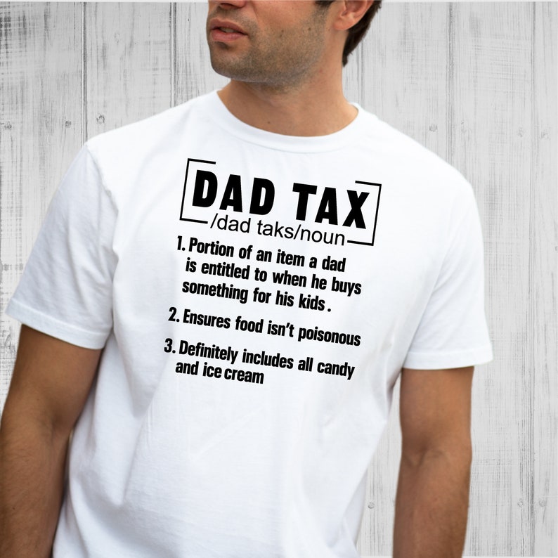 K&ouml;nnte beinhalten: Wei&szlig;es T-Shirt mit schwarzem Text, der "DAD TAX /dad taks/noun. 1. Portion of an item a dad is entitled to when he buys something for his kids. 2. Ensures food isn't poisonous 3. Definitely includes all candy and ice cream" lautet.