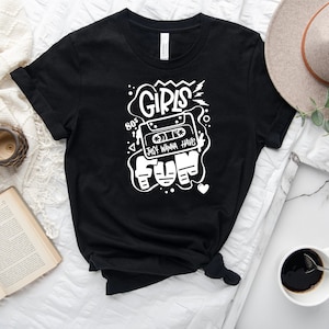 K&ouml;nnte beinhalten: Schwarzes T-Shirt mit einem wei&szlig;en Grafikdesign, das ein Kassettenband mit dem Text "80's Girls Just Wanna Have Fun" im Retro-Stil zeigt.