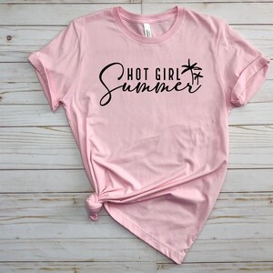 May include: Pink t-shirt with black text that reads "Hot Girl Summer" and a palm tree graphic.
