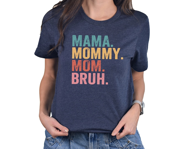 May include: A navy blue t-shirt with the text "MAMA. MOMMY. MOM. BRUH." in a retro font with colorful accents.