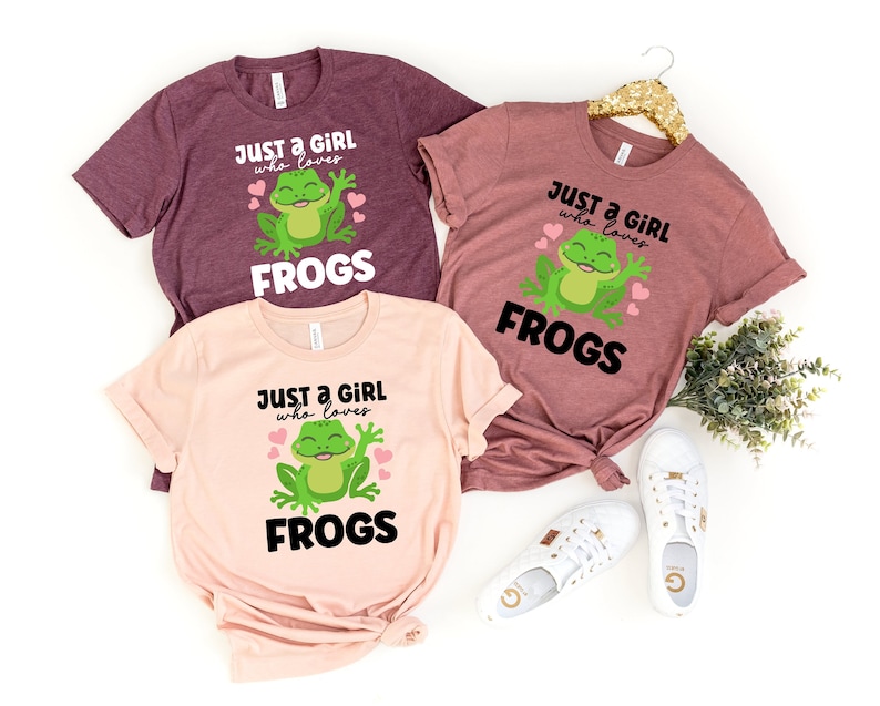 K&ouml;nnte beinhalten: Drei rosa und kastanienbraune T-Shirts mit einer gr&uuml;nen Froschgrafik und dem Text "Just a girl who loves frogs".