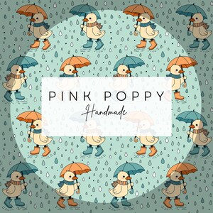 May include: A seamless pattern featuring a repeating design of yellow ducks wearing blue scarves and holding umbrellas. The ducks are walking in puddles of water with raindrops falling around them. The background is a light blue color with a white circle in the center. The text "PINK POPPY Handmade" is written in white on a white rectangle in the center of the circle.
