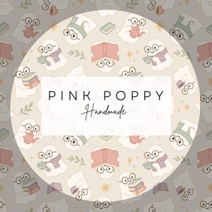 May include: A repeating pattern of cartoon ghosts wearing glasses, scarves, and hats, holding books and teacups. The background is a light beige color with small stars and leaves. The text "PINK POPPY Handmade" is in a white rectangle.
