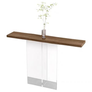 Puede incluir: Una mesa consola moderna con una tapa de madera marr&oacute;n y patas de acr&iacute;lico transparente. La mesa mide 122 cm de largo y 30 cm de profundidad.