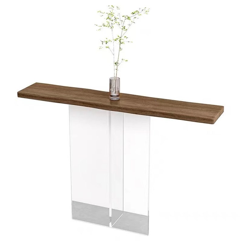 Puede incluir: Una mesa consola moderna con una tapa de madera marr&oacute;n y patas de acr&iacute;lico transparente. La mesa mide 122 cm de largo y 30 cm de profundidad.