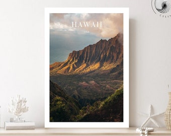 May include: A framed print of a mountain landscape with the text "HAWAII USA" at the top. The image shows a valley with a mountain range in the background. The sky is a light blue with some clouds.