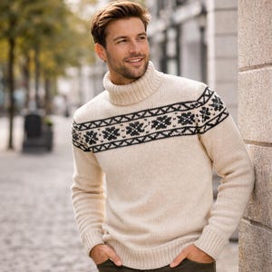 May include: Cream-colored turtleneck sweater with a black geometric pattern across the chest. The sweater has long sleeves and a ribbed turtleneck collar. The design is a classic, warm winter garment.