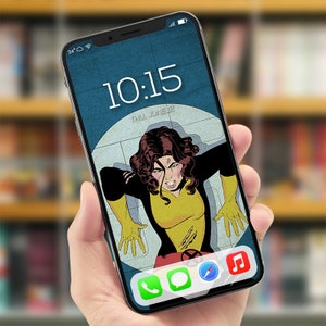 Op de afbeelding: Een smartphone die een digitale klok weergeeft met de tijd 10:15 en de datum "Thu June 2". De achtergrondafbeelding is een stripboekachtige illustratie van een vrouw met bruin haar en een geel en zwart kostuum. Het telefoonscherm toont ook pictogrammen voor een telefoongesprek, een sms-bericht, een kompas en muziek.