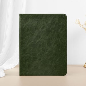 May include: A dark green leather notebook cover with a textured surface.