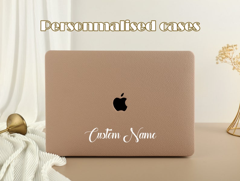 May include: A light brown laptop case with a black Apple logo and the text "Custom Name" in white cursive writing.