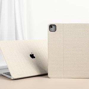 May include: Two beige laptop cases with a textured fabric design. The case on the left is open and shows a laptop with a white apple logo. The case on the right is closed.