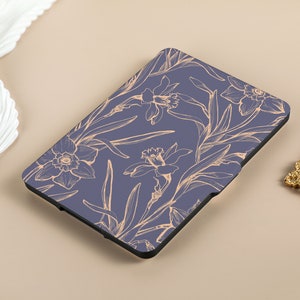 May include: A blue e-reader cover with a floral design featuring delicate, light orange daffodils on a dark blue background.