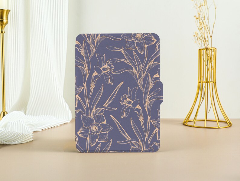 May include: A purple e-reader case with a floral pattern of daffodils in a light peach color.