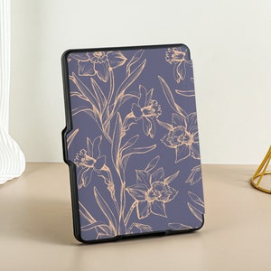 May include: A blue e-reader case with a floral design. The flowers are outlined in a light peach color and are on a dark blue background.