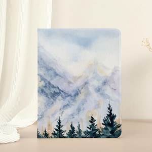 May include: Watercolor painting of a mountain range with a blue and purple color scheme. The mountains are in the background and there are a few trees in the foreground. The painting has a soft, dreamy feel.