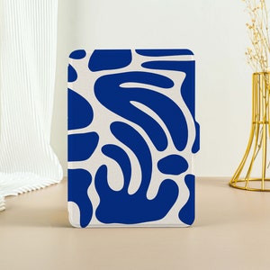 Könnte beinhalten: Eine Tablethülle mit einem abstrakten Muster in Weiß und Blau. Das Muster zeigt blaue organische Formen auf weißem Hintergrund.