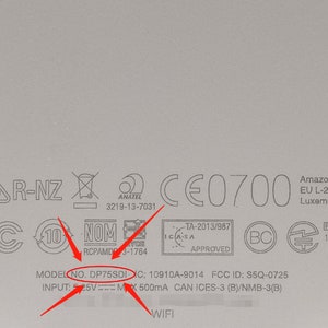 May include: Close-up of a white device with various certifications and regulatory markings, including FCC ID: S5Q-0725, IC: 10910A-9014, and Model No. DP75SDI. The device also has a WiFi logo and text indicating input of 5V = 500mA.