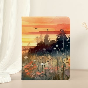 Pode incluir: Uma pintura em aquarela de um pôr do sol sobre um campo de flores silvestres. O céu é um laranja e amarelo vibrantes, e as flores são uma mistura de rosa, roxo e branco.