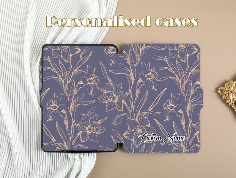 May include: A purple and gold floral patterned case for an e-reader. The case is open and the inside of the case has the text "Custom Name" written in gold.
