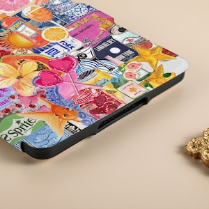 May include: A colorful phone case with a collage of images including a papaya, a goldfish, a star, a lollipop, a bottle of champagne, a bottle of gin, a lemon, a glass of wine, a bottle of soda, a cherry, a fish, a sun, a pineapple, a bottle of liquor, a grapefruit, a bottle of water, and a bottle of juice. The case is black and has a textured surface.